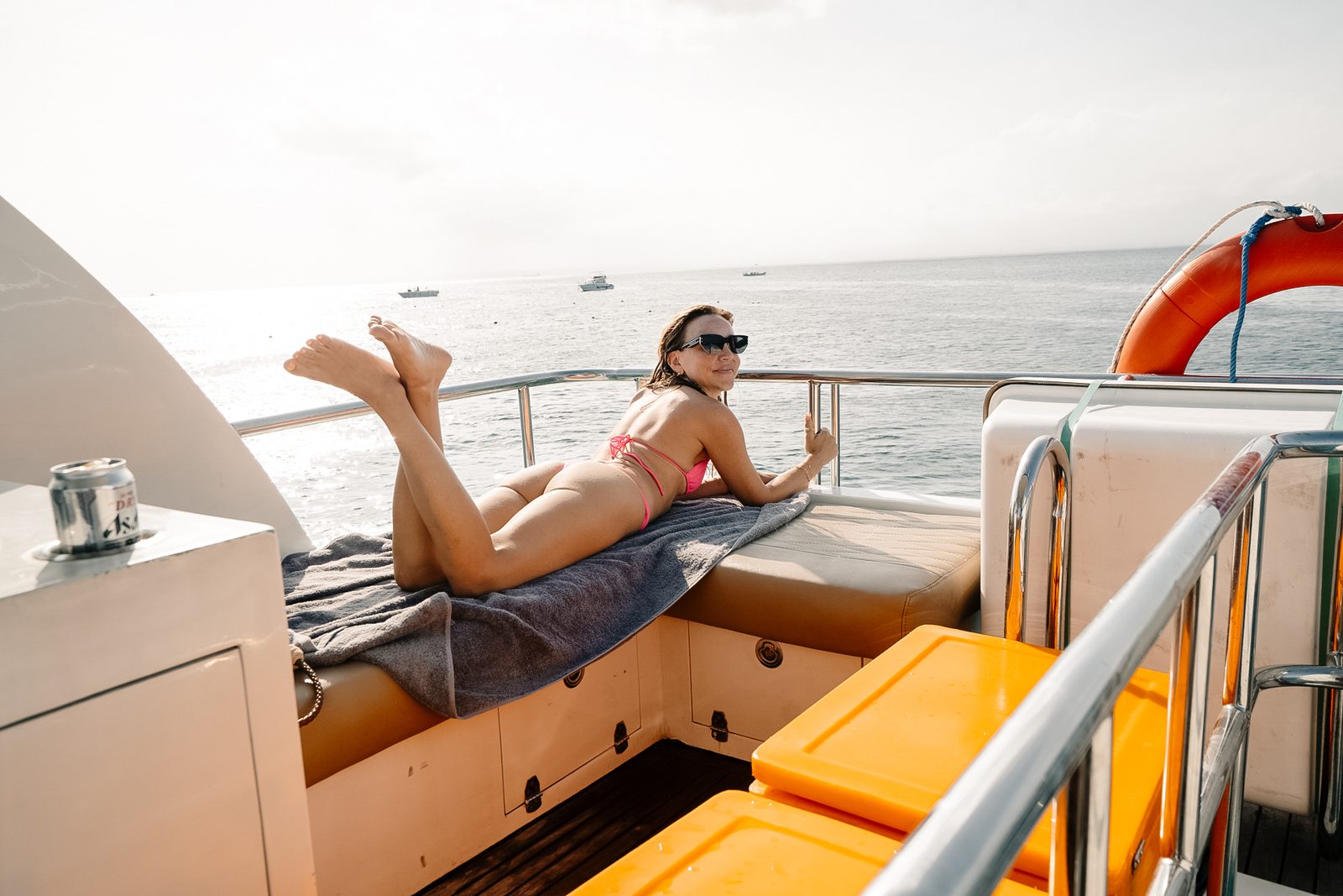 Guest relaxing on the sun deck of a private yacht at sunset in Bali
